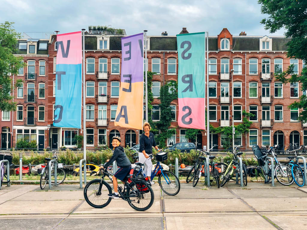 Ciclista di fronte a edifici colorati, in una scena urbana vivace